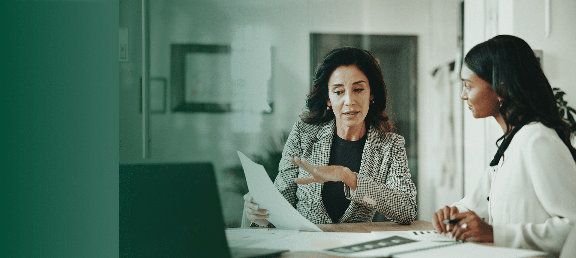 A professional woman reviewing documents in an office setting.