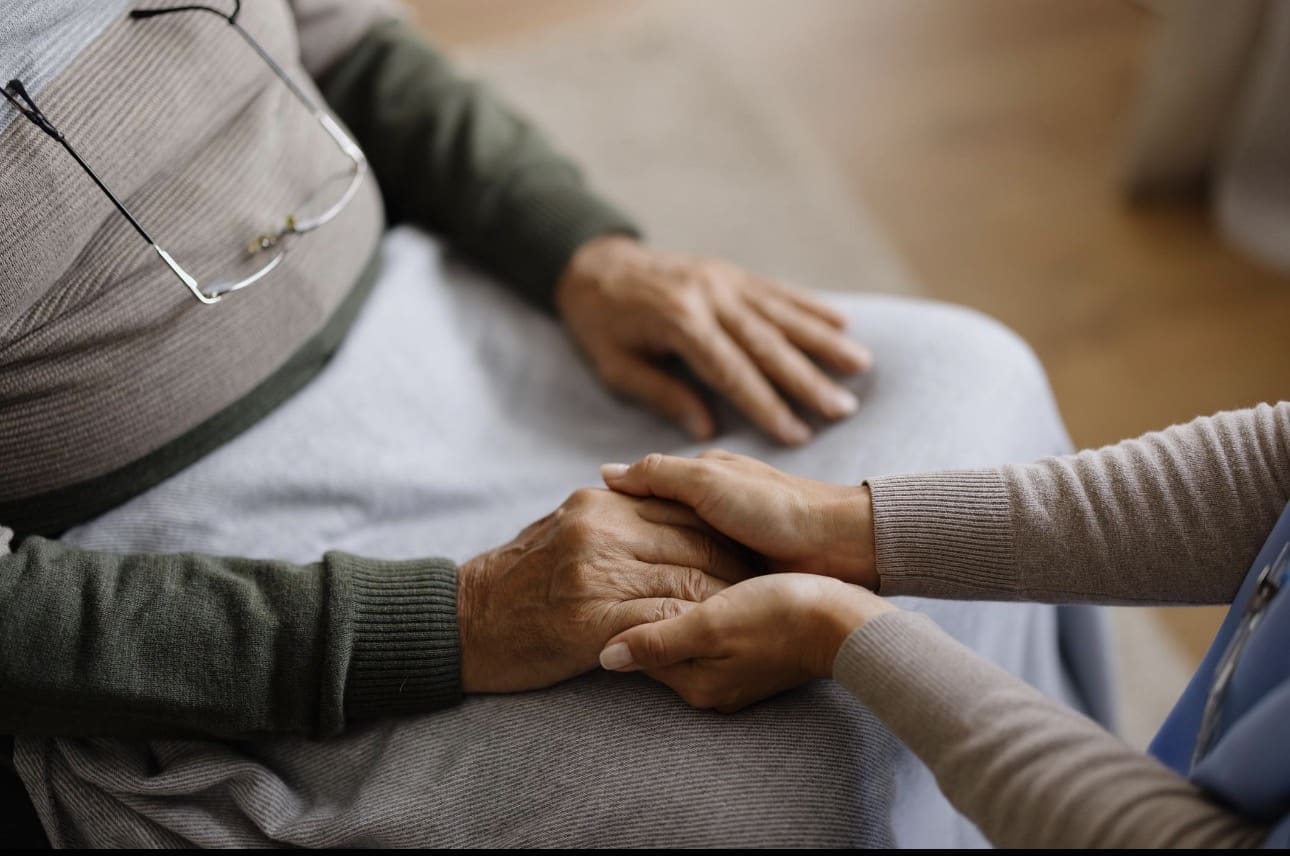 Two people holding hands, conveying care and support.
