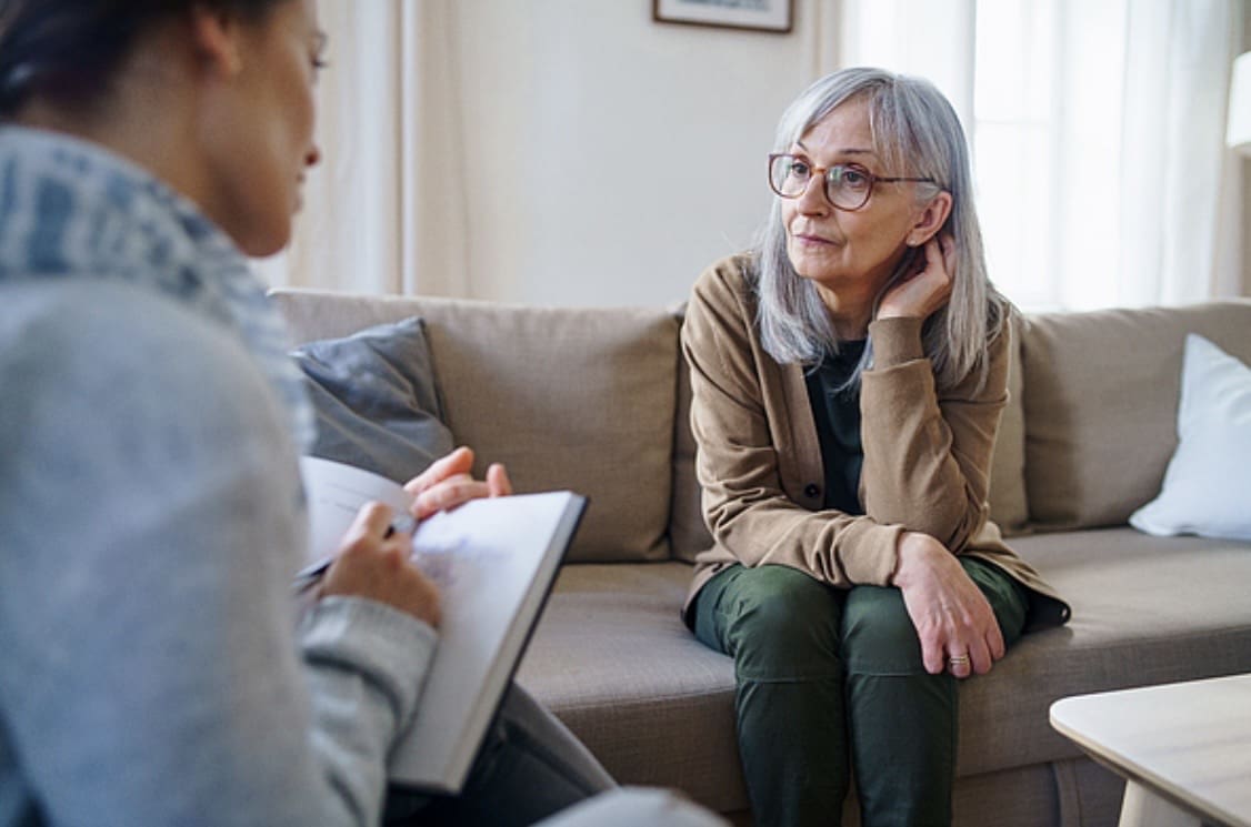 A woman attentively listens during a therapy session.